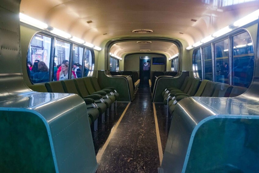 A subway car interior with green seats and overhead lighting. 3