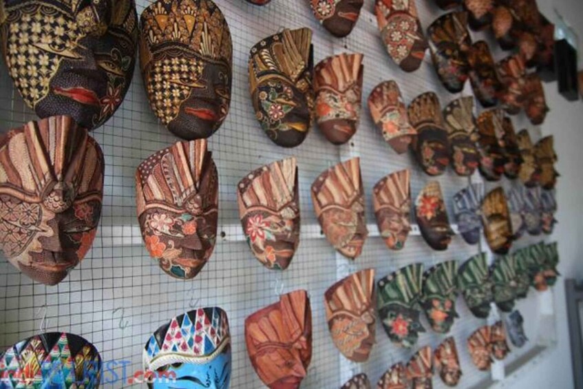 A variety of intricately designed masks displayed on a grid wall. 1