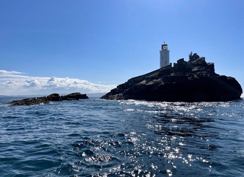 A lighthouse on a rocky outcrop with the ocean in the foreground. 4