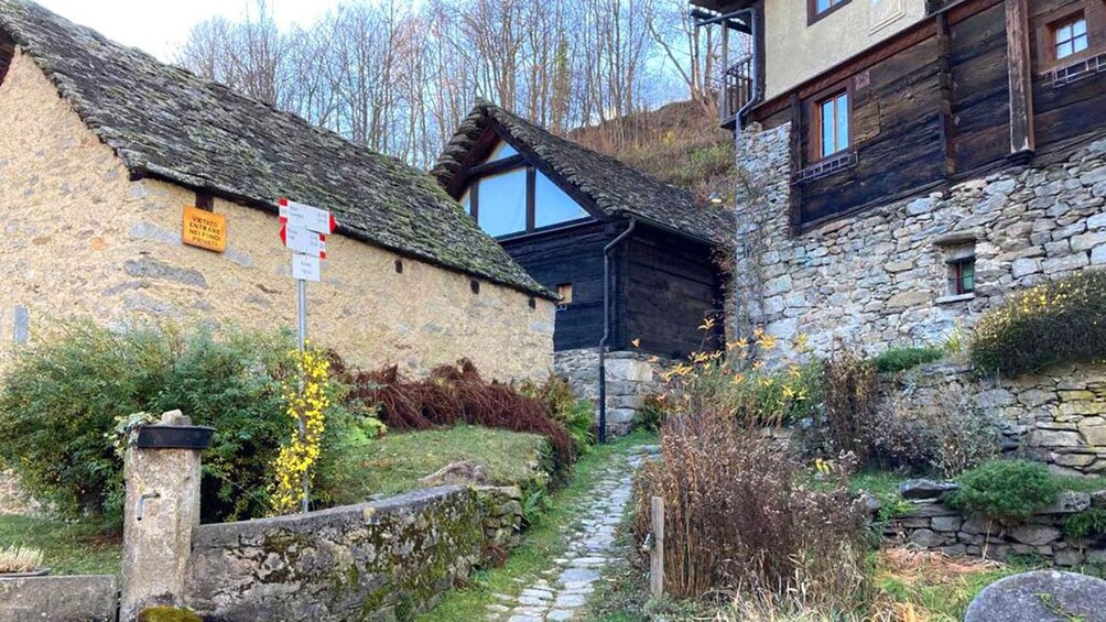A stone building with a thatched roof, a narrow stone path, and a sign indicating private property. 3