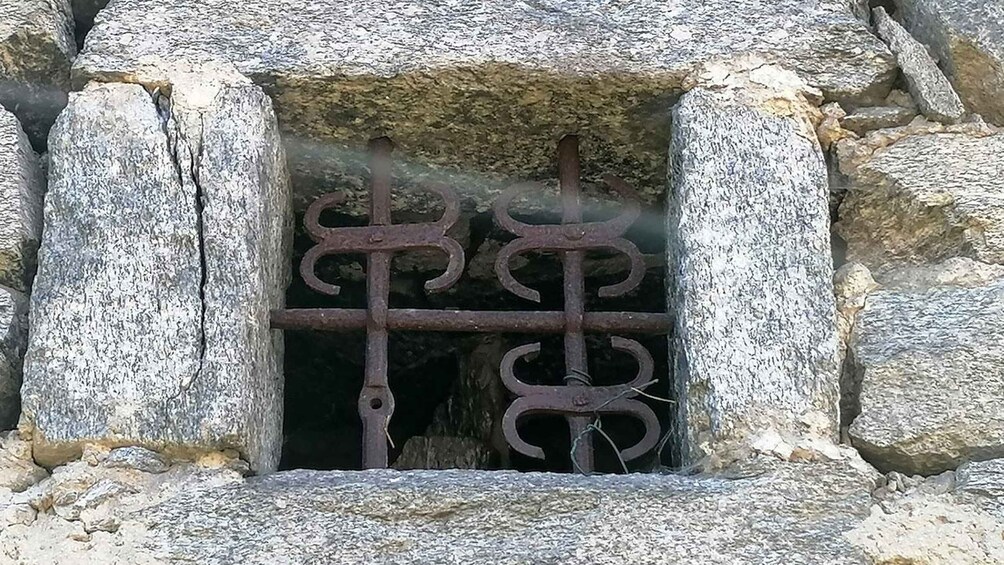 A stone window with a metal gate. 1