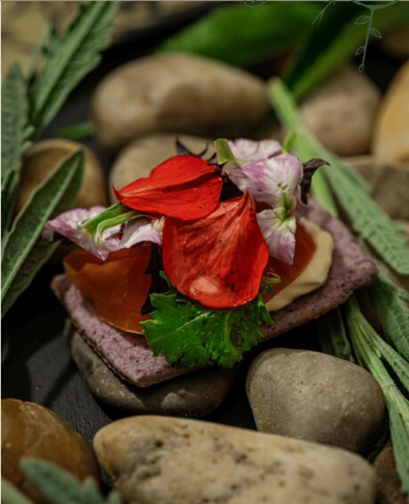 A flower arrangement with red and purple flowers on a stone surface. 2