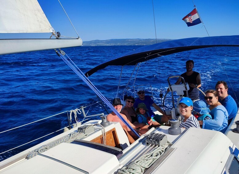 A group of people on a sailboat with a flag of Croatia. 3