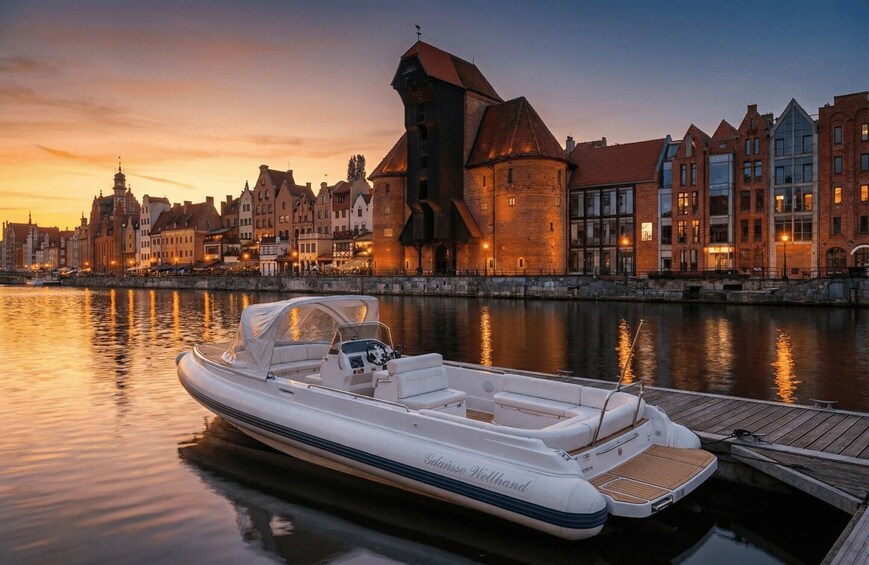 A white motorboat docked at a pier with a cityscape in the background. 5