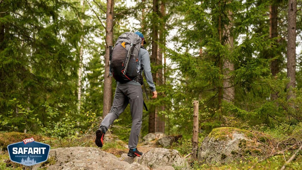 A person hiking in a forest with a backpack. 2