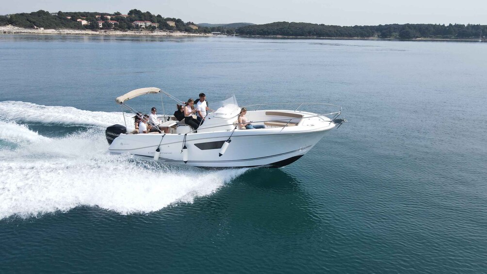 A white motorboat with passengers on a calm lake. 1