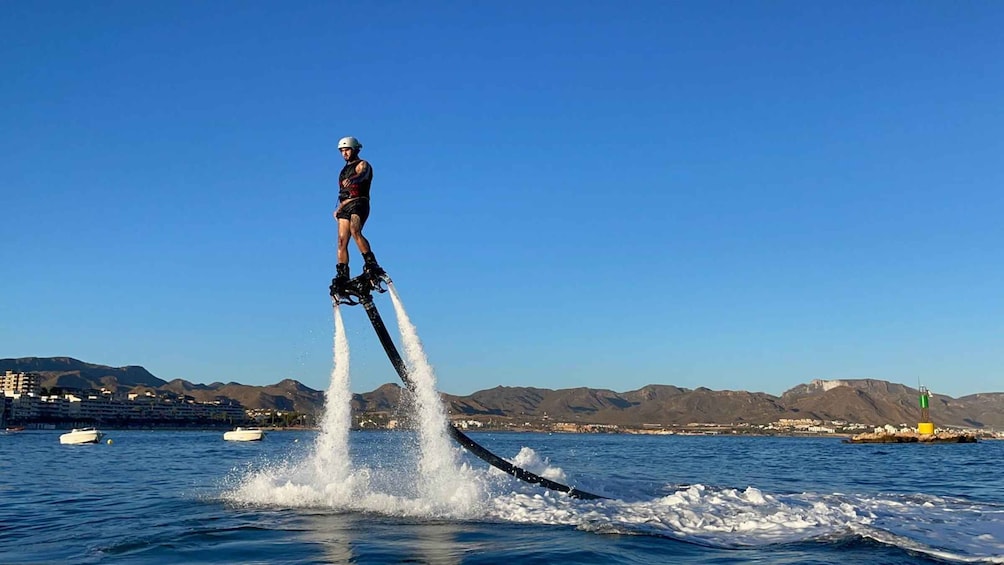 A person water skiing on a clear day with mountains in the background. 1