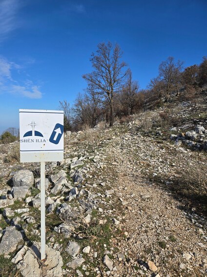 A sign with 'SHEN ILLIA' and directional arrows, surrounded by rocky terrain and sparse vegetation. 4