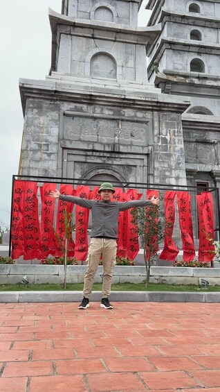 A person standing in front of a monument with red banners. 4