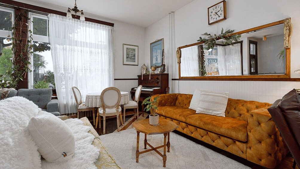 A living room with a sofa, a coffee table, a fireplace, and a large mirror. 5