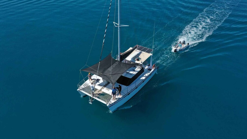 A sailboat with a covered deck and a person standing at the stern. 3