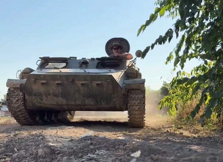 A military tank on a dirt road with vegetation on the side. 4