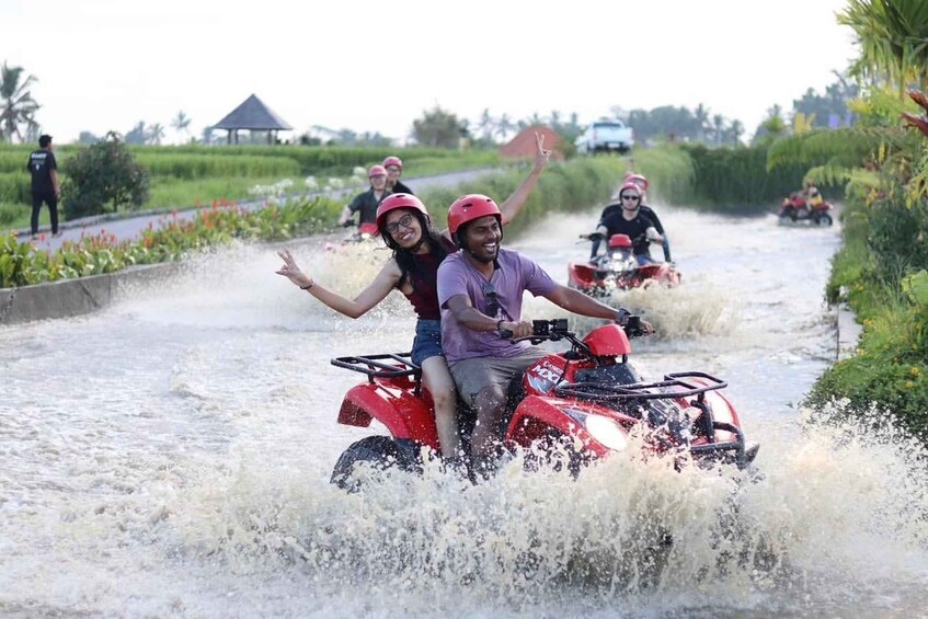 People riding quad bikes through a flooded rural road. 3