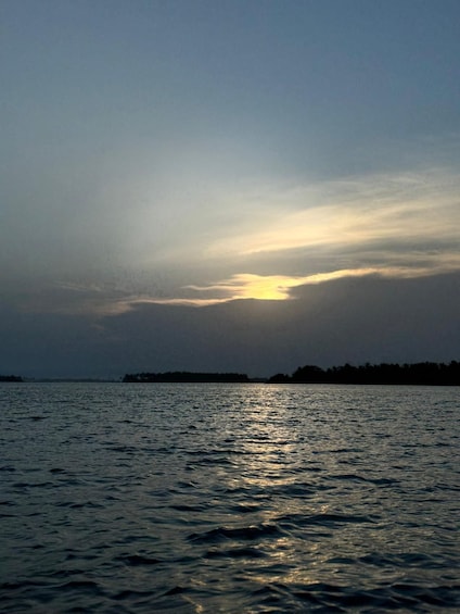 A sunset over a calm sea with a distant shoreline. 4