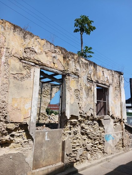 A dilapidated building with exposed brickwork and a single window. 3