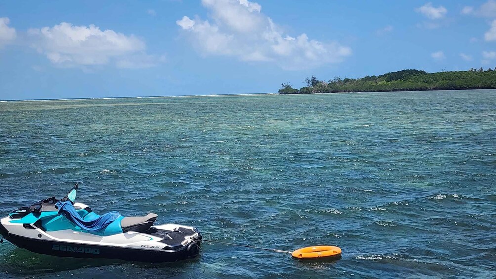 A jet ski on calm waters with a clear sky and a distant island. 2