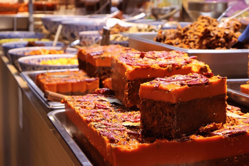 A buffet with various dishes, including a prominent section of orange-colored baked goods. 2