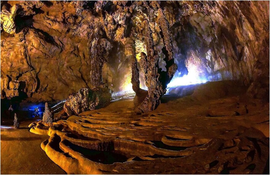A cave with stalactites and a lit pathway. 3
