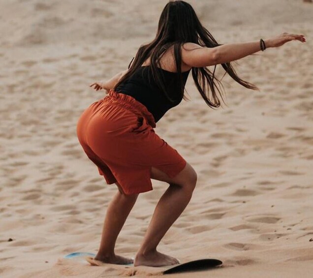 A person surfing on a sandy beach. 4