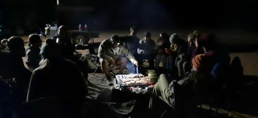 A group of people gathered around a campfire at night. 5