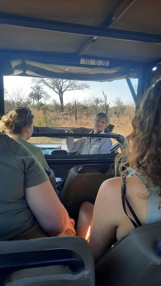 A safari vehicle with three passengers. 2