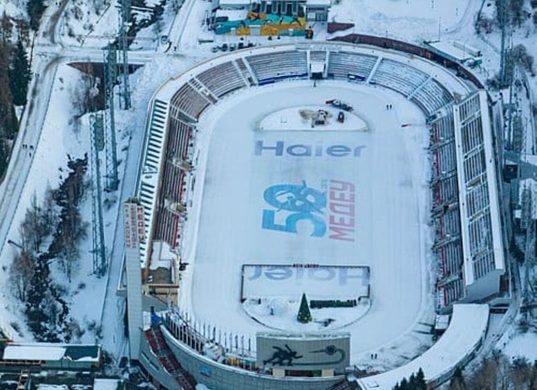 An ice hockey rink surrounded by snow-covered buildings. 5