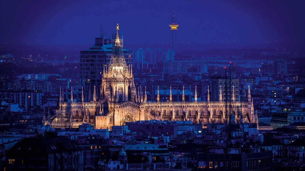 A Gothic cathedral at night with a spire and intricate facade, surrounded by a cityscape. 2