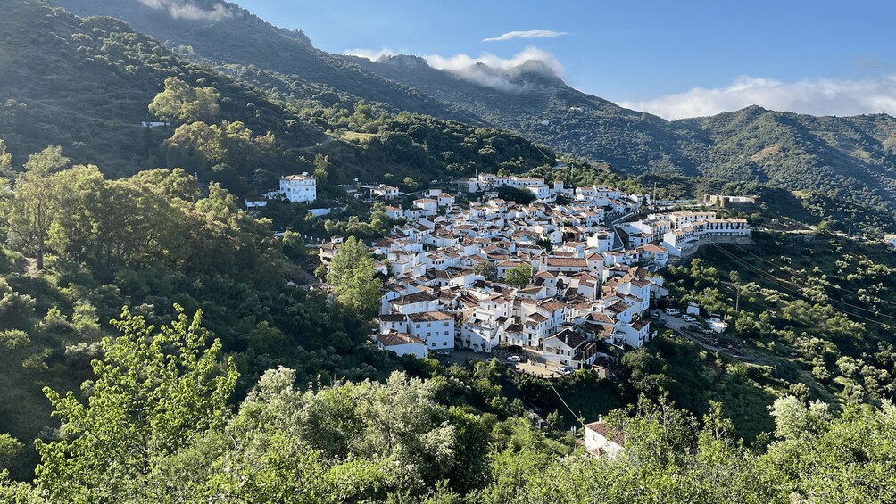 Un pueblo montañoso de edificios blancos enclavado en un exuberante verdor. 2