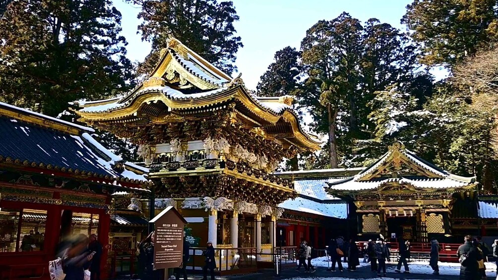 Traditional East Asian architecture with ornate golden roofs and red walls, surrounded by snow. 3