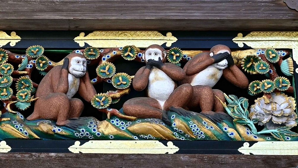 A detailed sculpture of three monkeys with intricate patterns and designs. 2