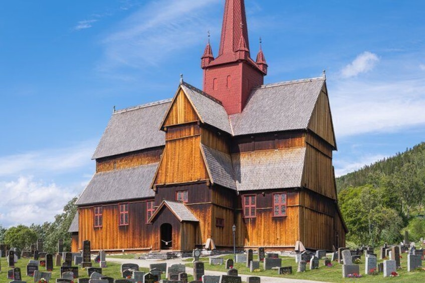 A wooden church with a red steeple, surrounded by a cemetery. 3