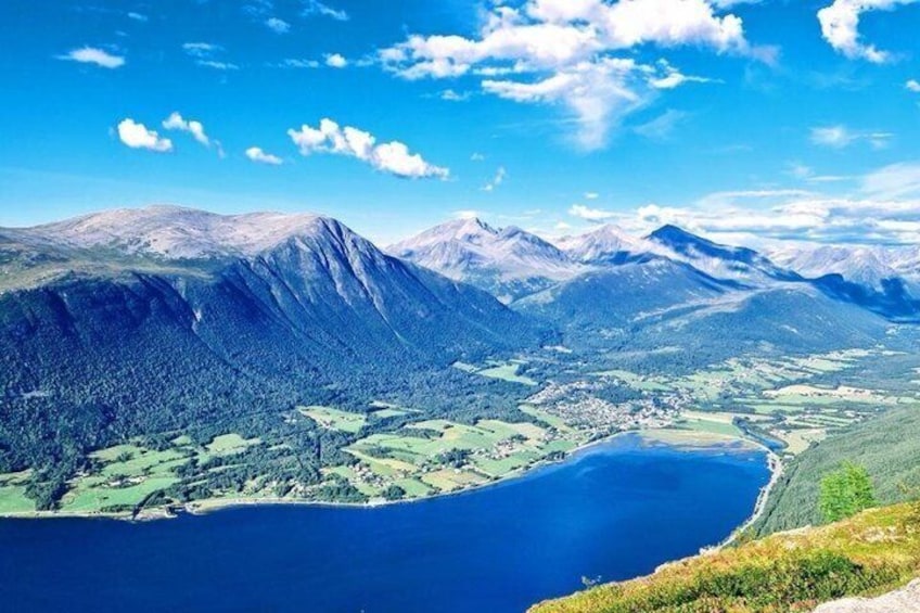 A mountainous landscape with a lake and a small town. 1