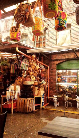 A market stall with colorful woven baskets and hanging items. 3