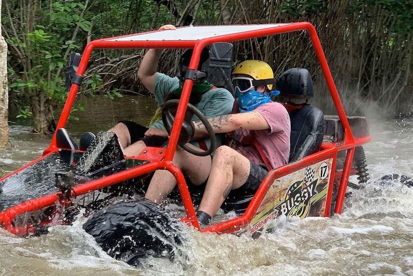 A red off-road vehicle navigating through a waterlogged area with dense vegetation. 2