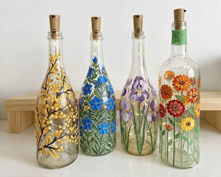 Four glass bottles with floral designs. 1