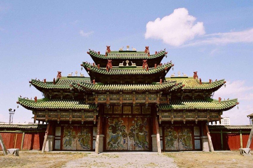 A traditional multi-tiered building with ornate green roofs and detailed murals. 4