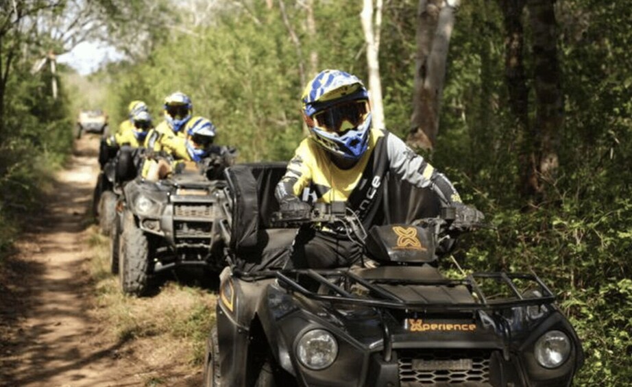 A group of ATV riders on a forest trail. 4