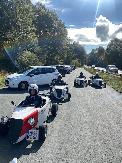 A convoy of vehicles on a road with trees and a clear sky. 3