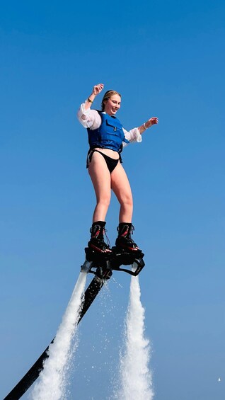 A person performing a high jump on a water jetpack. 1