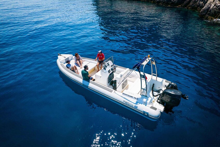 A small motorboat with four people on a calm body of water. 1