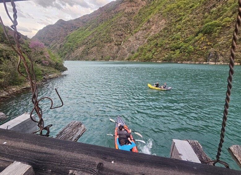 A river with boats, a wooden dock, and a mountainous landscape. 5