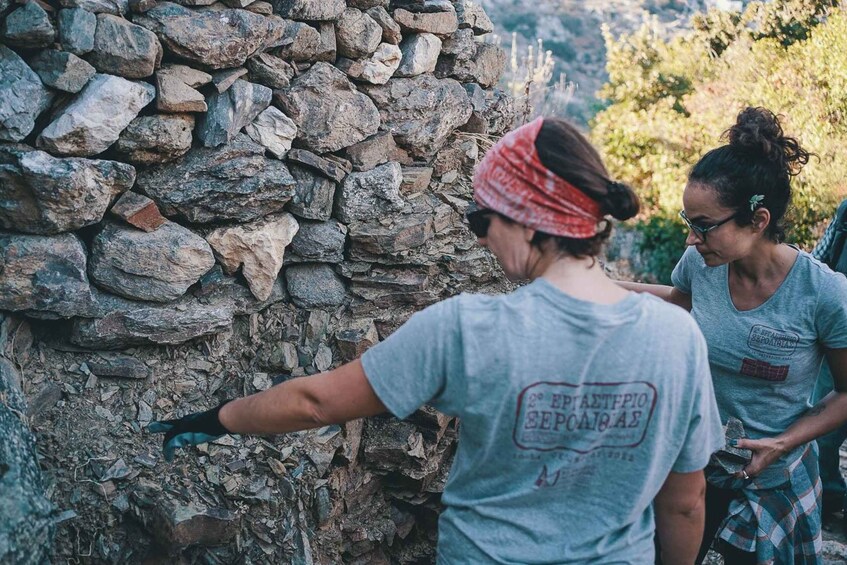 Two people examining a stone wall. 2