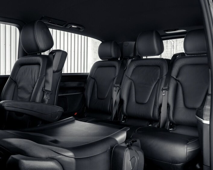 A car interior with black leather seats, a center console, and a sunroof. 4