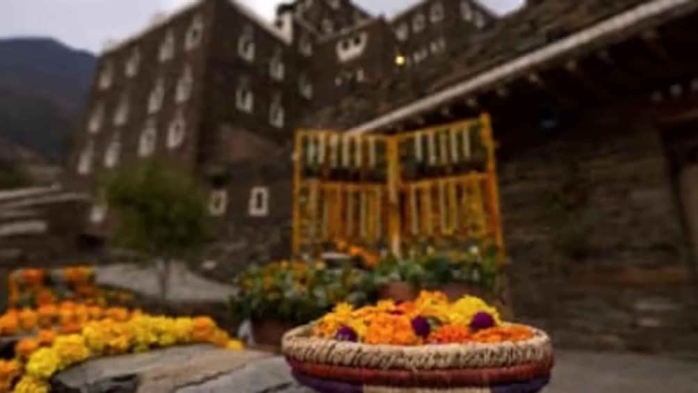 A traditional building with a gate, surrounded by a circular flower arrangement. 5