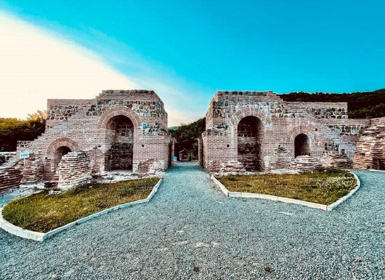 Ancient ruins with arched doorways and a clear sky. 2