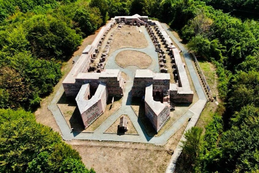 An ancient stone structure surrounded by dense greenery. 4