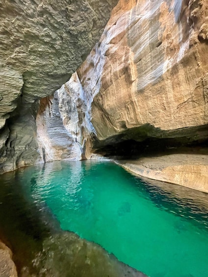 A cave with turquoise water and rock formations. 2