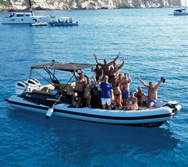 A group of people on a boat with the sea and rocky cliffs in the background. 4