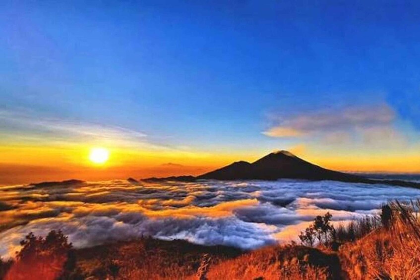A mountain at sunrise with clouds below. 3
