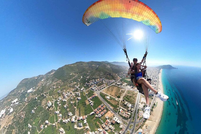 A person paragliding over a coastal area with a view of a town and the sea. 3